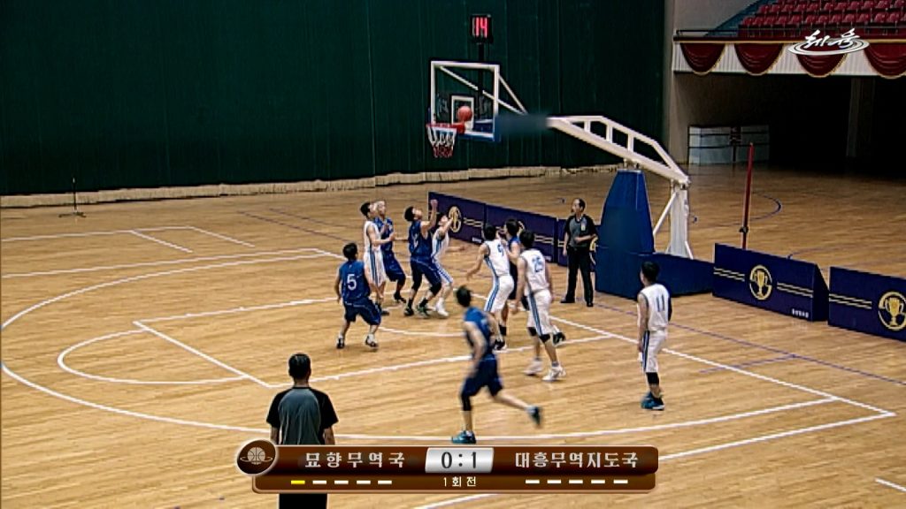 The image shows a television screenshot of a basketball match underway